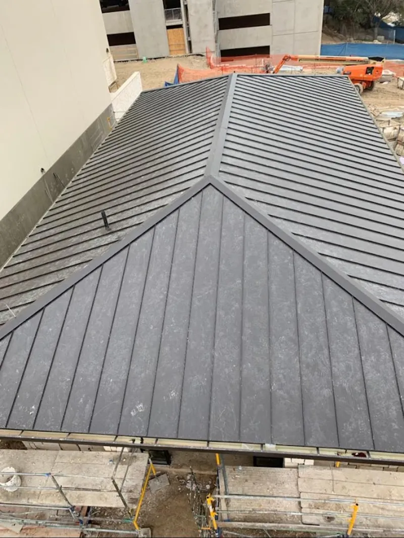 Commercial metal roof construction with crane equipment in Leeds